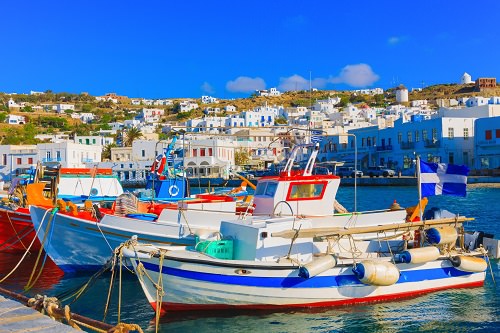 Colorful wooden fishing boats on row Mykonos island old port Gr