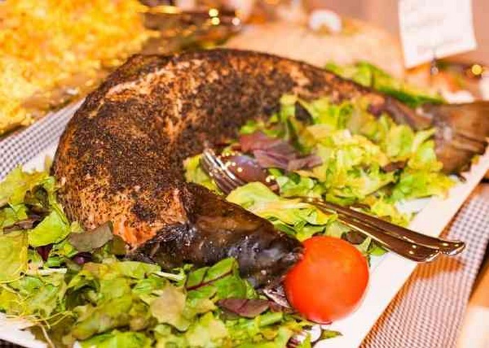 Whole baked salmon stuffed with lemon and herbs, vegetables