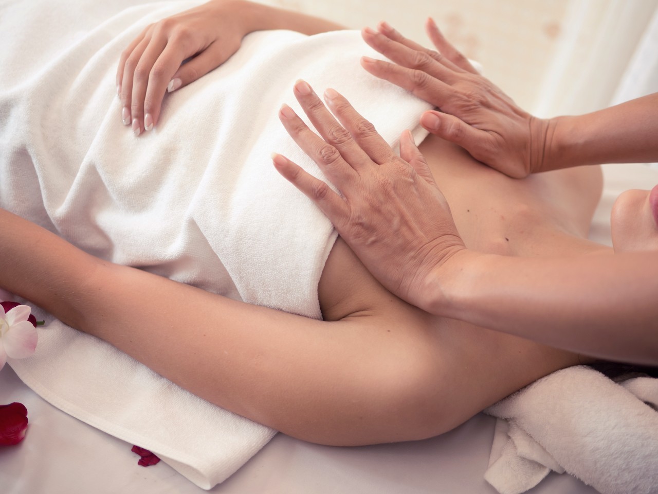 Masseur doing massage on woman breasts in the spa salon.